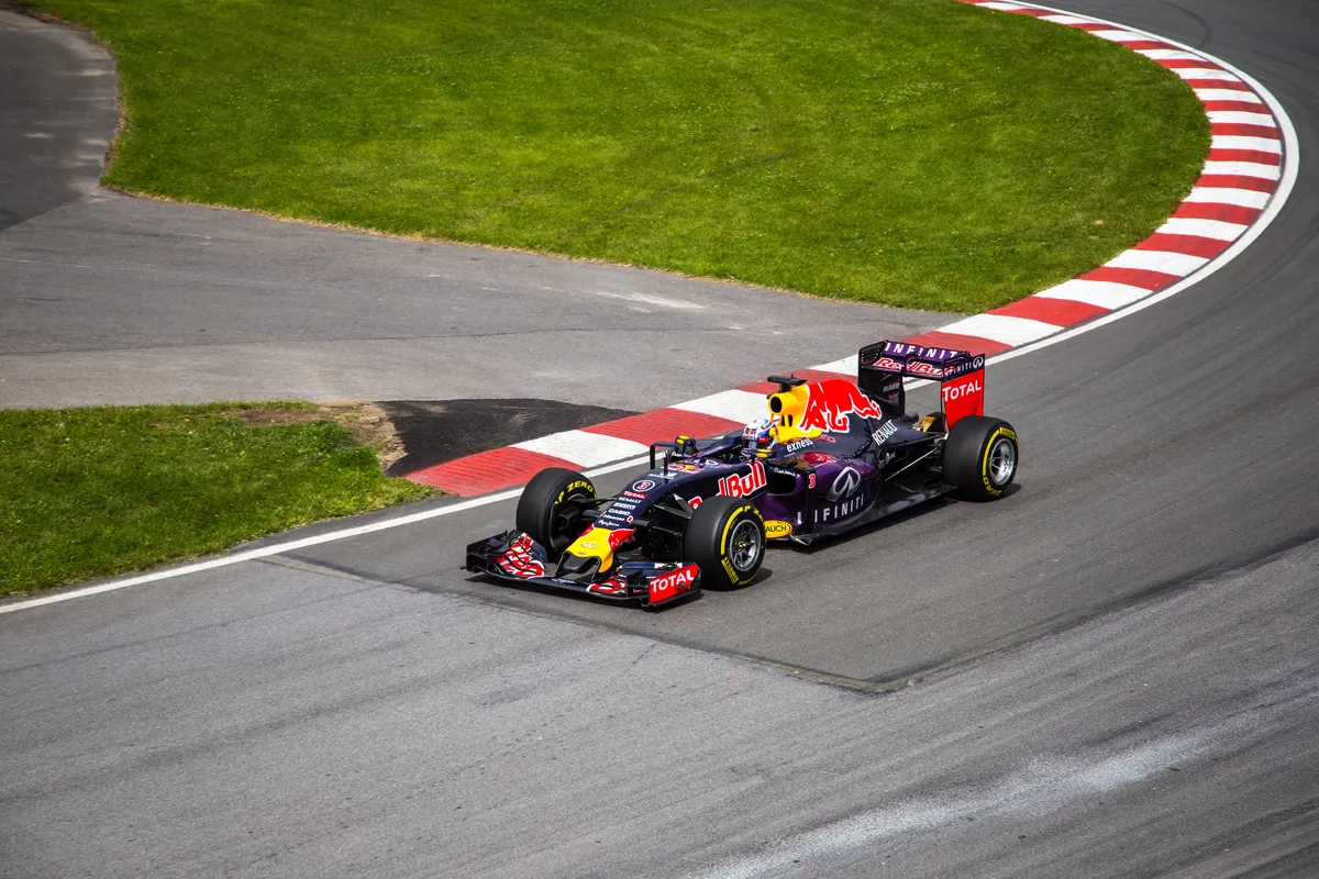 Red-Bull-Rennwagen in der Lackierung von 2015 fährt auf dem Circuit Gilles Villeneuve in Montreal durch eine Kurve mit rot-weißen Randsteinen