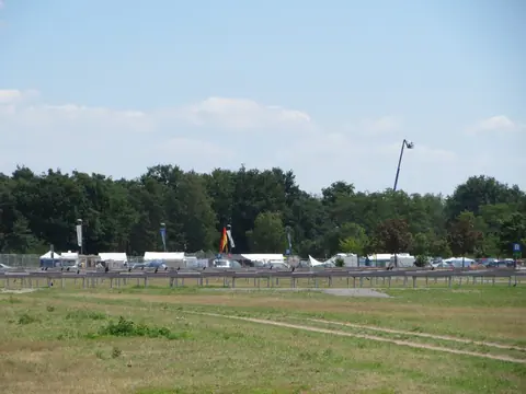 Zelte und Wohnwagen auf dem Campingplatz am Hockenheimring während des Rennwochenendes 2014, davor eine Wiese, dahinter Wald